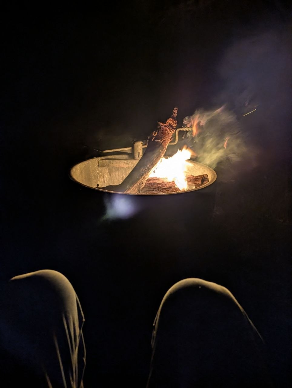 A campfire burning in a metal fire ring at night at Black Rock Campground