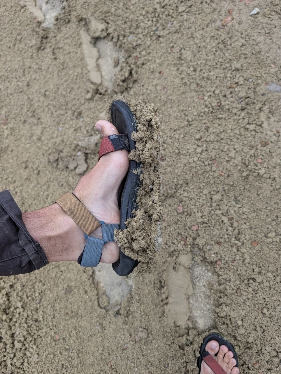 A sandal packed with thick mud from the Painted Hills after rain