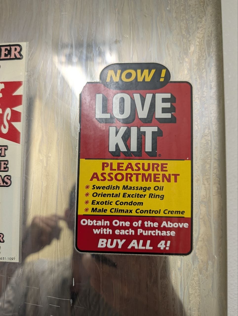 A bathroom vending sticker advertising a Love Kit pleasure assortment
