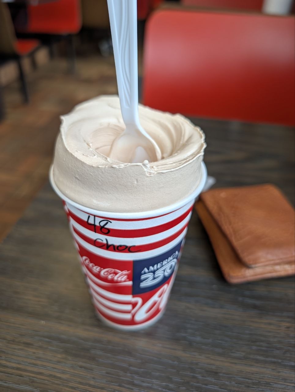 A chocolate milkshake in a red-and-white paper cup at Henrie's in Panguitch, Utah
