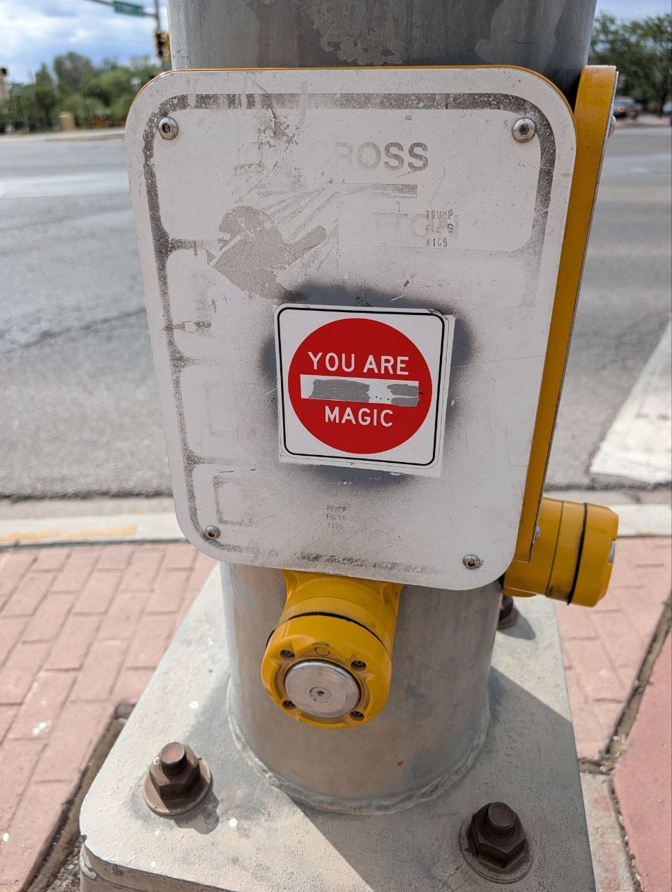 A Santa Fe crosswalk button with a red sticker reading You Are Magic