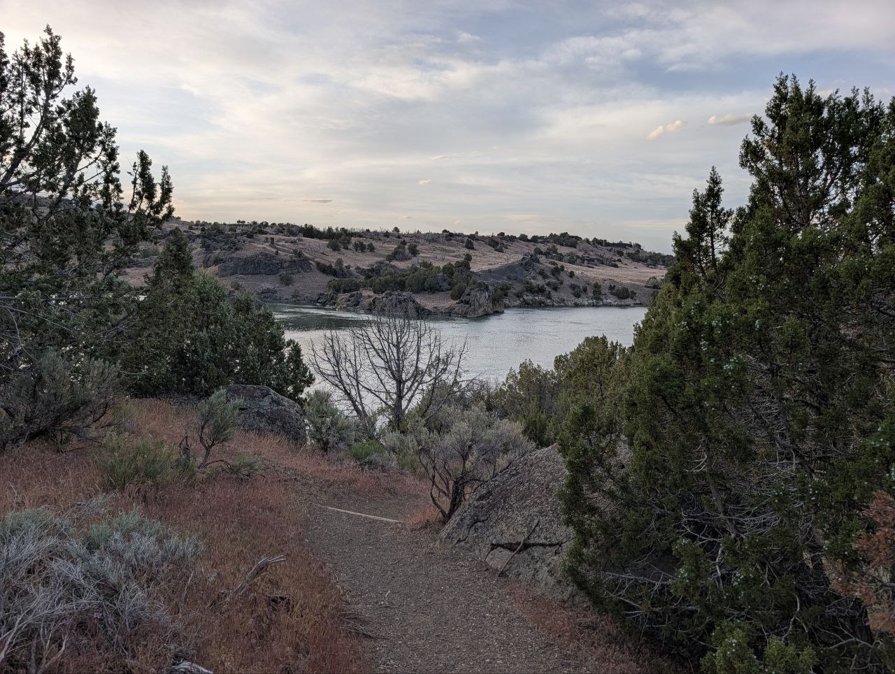 A trail descending through sage and juniper toward the Snake River