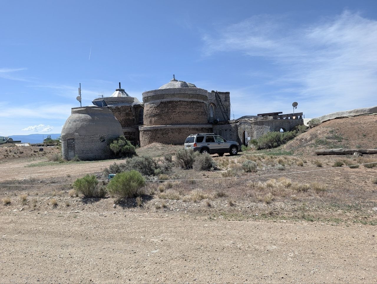 Rounded Earthship structures on the Taos mesa under blue sky